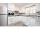 Well-lit kitchen features white cabinets, stainless steel appliances, granite countertops and wood-look tile floors at 1887 King Charles Sw Rd, Atlanta, GA 30331