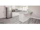 Modern kitchen features stainless steel appliances, white cabinets, breakfast bar, and wood-look flooring at 1887 King Charles Sw Rd, Atlanta, GA 30331