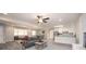Open floor plan with living room leading to the kitchen, with a gray sofa, wood floors, and a ceiling fan at 1887 King Charles Sw Rd, Atlanta, GA 30331