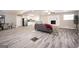 An open-concept living room featuring sleek, gray-toned wood-look flooring and a stylish brick fireplace at 1887 King Charles Sw Rd, Atlanta, GA 30331