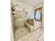 A gorgeous glass door shower is attached to a soaking tub and tan tile at 2706 Park Land Ln, Snellville, GA 30078