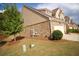 Exterior view of a well-maintained townhome featuring brick accents, a manicured lawn, and attached garage at 2706 Park Land Ln, Snellville, GA 30078