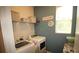 The laundry room features a front loading washer and dryer and shelving at 2706 Park Land Ln, Snellville, GA 30078