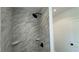 A shower clad in marble tile with modern black fixtures at 5510 Mason Rd, Atlanta, GA 30349
