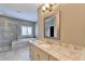 This light and airy bathroom has granite counters, double sinks, a bathtub, and a glass shower at 828 Olmsted Ln, Duluth, GA 30097