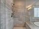 Bright bathroom featuring a walk in shower with gray tile and a view to the backyard at 828 Olmsted Ln, Duluth, GA 30097
