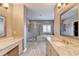 Bright bathroom featuring double sinks with granite countertops, a soaking tub, and a glass shower at 828 Olmsted Ln, Duluth, GA 30097