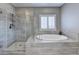 Bright bathroom featuring a glass enclosed shower and soaking tub at 828 Olmsted Ln, Duluth, GA 30097