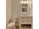 Cozy bathroom with vanity, sink, lighting, and toilet at 828 Olmsted Ln, Duluth, GA 30097