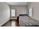 Neutral bedroom with hardwood floors, a metal frame bed, and white blinds in windows at 828 Olmsted Ln, Duluth, GA 30097