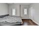 Neutral bedroom featuring hardwood floors, two windows, and a neatly made bed at 828 Olmsted Ln, Duluth, GA 30097
