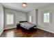 Neutral bedroom with a dark wood floor, two windows with blinds, and a metal frame bed at 828 Olmsted Ln, Duluth, GA 30097