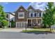 Charming two-story home featuring a covered porch, attached garage and manicured lawn at 828 Olmsted Ln, Duluth, GA 30097