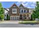 Charming two-story home featuring a covered porch, attached garage and manicured lawn at 828 Olmsted Ln, Duluth, GA 30097
