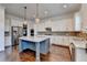 A modern kitchen features a large island, stainless steel appliances, granite counters, and decorative pendant lights at 828 Olmsted Ln, Duluth, GA 30097