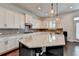 A modern kitchen features a large island, granite counters, white cabinets, and dark hardwood floors at 828 Olmsted Ln, Duluth, GA 30097