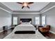 Beautiful main bedroom with trey ceilings, modern fan, hardwood floors, and leather chair at 828 Olmsted Ln, Duluth, GA 30097