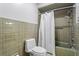 Clean bathroom with green tiled shower with new shower head and new toilet at 1075 Winding Branch Ln, Atlanta, GA 30338