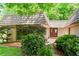 Attractive front entrance featuring a red double door, wood deck, mature landscaping, and unique roofline at 1075 Winding Branch Ln, Atlanta, GA 30338