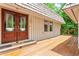 Spacious front porch featuring wooden deck and double front doors with glass panels at 1075 Winding Branch Ln, Atlanta, GA 30338