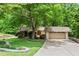 Lovely front yard with mature landscaping, stone retaining wall, and a cozy home with a two-car garage at 1075 Winding Branch Ln, Atlanta, GA 30338