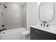 A stylish bathroom showcases a vanity, a tub with shower, modern fixtures, and white and gray tiling at 1287 Star Ne Dr, Brookhaven, GA 30319