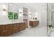 Modern bathroom with wood vanities, double sinks, elegant mirrors, glass shower, and marble tile flooring at 1287 Star Ne Dr, Brookhaven, GA 30319