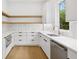Bright kitchen featuring white cabinets, a stainless steel dishwasher, and light wood shelving at 1287 Star Ne Dr, Brookhaven, GA 30319