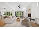 Open-concept living room with hardwood floors, a modern fireplace, and large windows overlooking the backyard at 1287 Star Ne Dr, Brookhaven, GA 30319