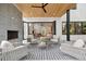 A covered patio features modern furniture, an outdoor fireplace, and a view of the lush backyard at 1287 Star Ne Dr, Brookhaven, GA 30319