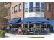 Outdoor seating at Verde restaurant with blue awnings, umbrellas, and brick exterior, perfect for dining at 1287 Star Ne Dr, Brookhaven, GA 30319