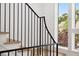 Modern staircase features black metal railings and light wood treads, brightened by a nearby window at 1287 Star Ne Dr, Brookhaven, GA 30319