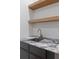 An elegant wet bar features marble countertops, dark cabinetry, and floating wood shelves at 1287 Star Ne Dr, Brookhaven, GA 30319