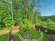 Aerial view of backyard featuring well-maintained lawn, stone path and border of mature trees at 150 Holden Way, Woodstock, GA 30189