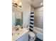Bright bathroom featuring a vanity and a tub/shower combo with blue striped shower curtain at 150 Holden Way, Woodstock, GA 30189