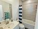 Bright bathroom featuring a vanity and a tub/shower combo with blue striped shower curtain at 150 Holden Way, Woodstock, GA 30189
