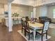 Open-concept living space with hardwood floors, dining table, and a view into the bright kitchen and living room at 150 Holden Way, Woodstock, GA 30189