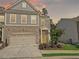 Charming two-story home with a brick facade, two-car garage, landscaped yard and a welcoming, bright yellow front door at 150 Holden Way, Woodstock, GA 30189