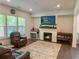 Cozy living room with hardwood floors, a brick fireplace, and plenty of natural light at 150 Holden Way, Woodstock, GA 30189