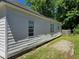 Exterior view of a home, showing the simple, white siding and surrounding landscape, with a small garden area at 112 Brown Se Ave, Atlanta, GA 30315
