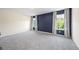 Bedroom featuring plush gray carpeting, an accent wall, and large windows with streaming natural light at 2440 Rocky City Ln, Snellville, GA 30078