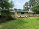 View of the home's backyard with a brick chimney, showing a grassy area and surrounding trees at 108 Fair Oaks Se Dr, Conyers, GA 30094