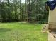 Backyard view showing the house exterior and lawn. The area is surrounded by mature trees at 108 Fair Oaks Se Dr, Conyers, GA 30094