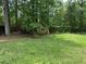 A portion of the backyard area with a small outbuilding featuring a window, nestled between trees at 108 Fair Oaks Se Dr, Conyers, GA 30094