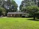 Charming single-story home featuring red shutters and a sprawling green lawn at 108 Fair Oaks Se Dr, Conyers, GA 30094