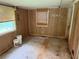 This room features wood paneled walls, a window, and dated floors at 108 Fair Oaks Se Dr, Conyers, GA 30094