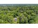 Aerial view of a modern farmhouse nestled amongst lush green trees in a serene, wooded setting at 1870 Twin Branch Dr, Marietta, GA 30062