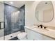 Modern bathroom featuring glass shower with herringbone tile, round mirror, and white vanity at 1870 Twin Branch Dr, Marietta, GA 30062
