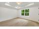 Sunlit bedroom with tray ceiling, hardwood floors, and a large window offering a scenic view of greenery at 1870 Twin Branch Dr, Marietta, GA 30062