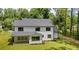 Rear exterior of a modern farmhouse showcasing black framed windows, a covered porch, and lush landscaping at 1870 Twin Branch Dr, Marietta, GA 30062